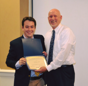 two men posing with award