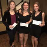 three girls posing with awards