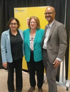 Posing and smiling at a camera off screen, from left to right: School of Business Dean Sunita Ahlawat, Senator Linda Greenstein, and School of Humanities and Social Sciences Dean Christopher Fisher.